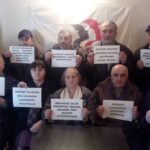 Mineros georgianos muestran carteles con sus demandas al Gobierno y a la empresa.