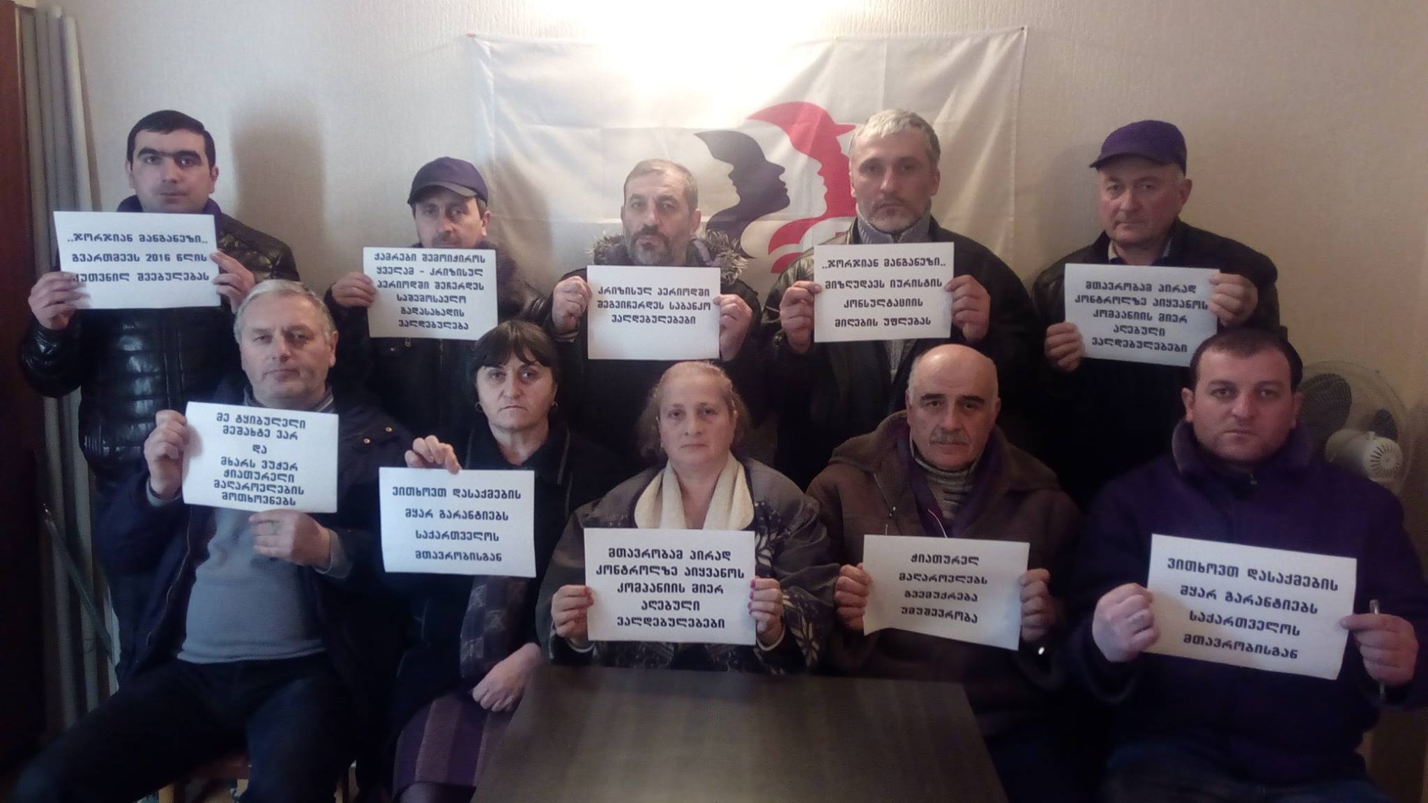 Mineros georgianos muestran carteles con sus demandas al Gobierno y a la empresa.