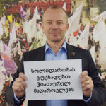 Jyrki Raina, secretario general de la IndustriALL Global Union, con un cartel en solidaridad con los mineros georgianos.