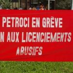 The sign reads "Petroci on strike. No to abusive layoffs"
