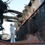 Shipbreaking worker Naseeb Gul stands inside the burnt out oil tanker pointing out where the explosion ripped apart the tanker. Photo: IndustriALL/Amar Guriro