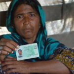 38-year-old Zaloo, holds up the identity card of her 18-year-old son Noor Bux who perished in the oil tanker inferno. Photo: IndustriALL/Amar Guriro
