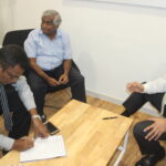 Anton Marcus (centre) of the FTZ & GSEU at the signing of the agreement with management