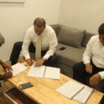 Anton Marcus (left) of the FTZ & GSEU signs the agreement with management