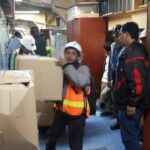 La policía protege a un equipo de la dirección mientras se recogen los bienes personales de trabajadores despedidos