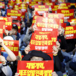 KMWU union members hold signs reading, “Enact the Chaebol Reform Bill and Special Act for Development of the manufacturing base” while shouting slogans for Chaebol reform.  Photo: SHIN, Dong-Jun