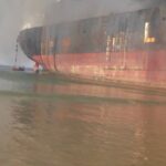 Workers climb down a ladder to be rescued by lifeboat.