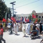 Los trabajadores atraviesan la Universidad de Gujrat, el 7 de octubre de 2014